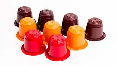 Three rows of red, orange, and dark brown coffee pods arranged on a white surface.