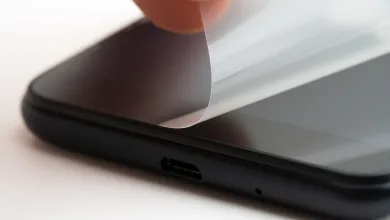 Hand peeling protective film from a smartphone screen