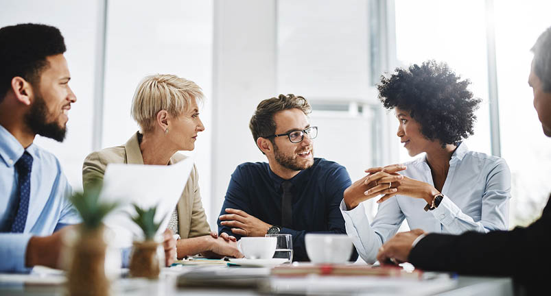 Cropped shot of a diverse group of businesspeople sitting together and having a meeting in the office